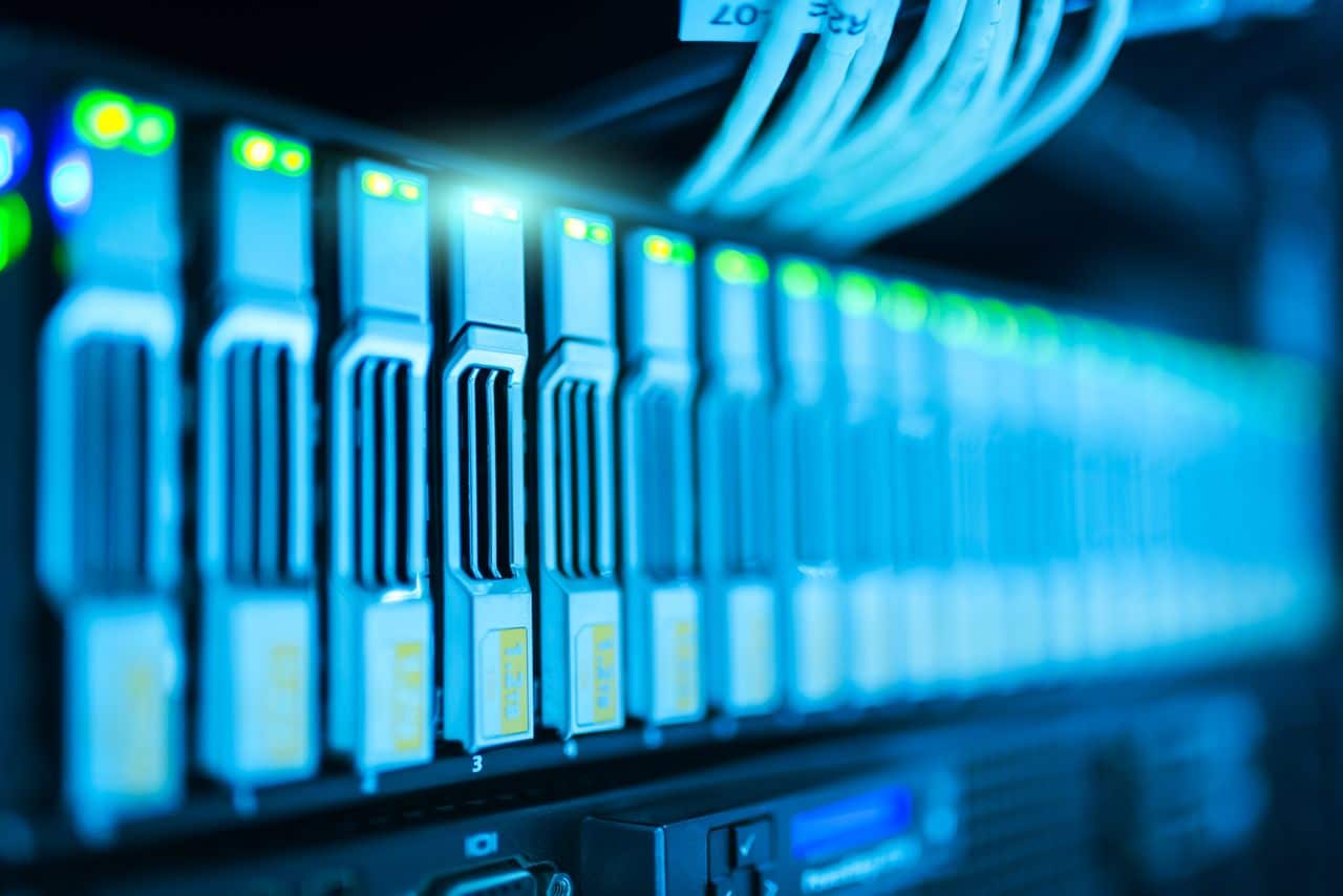 why-choose-us-02 Detailed image of a server rack with glowing lights in a modern data center.