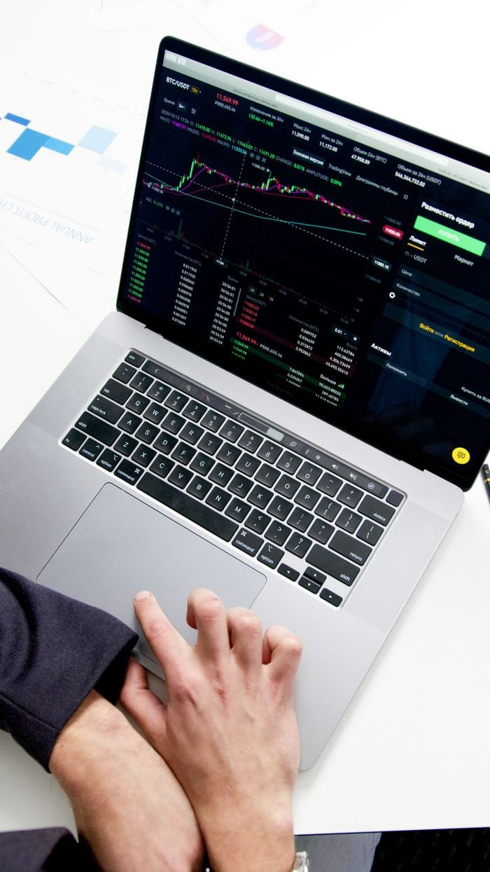 services-01 Professional analyzing stock market graphs on a laptop, showcasing investment insights.